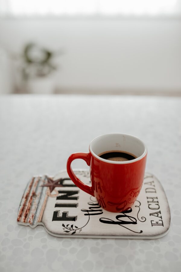 Vertical shot of a cup of hot coffee on a coaster